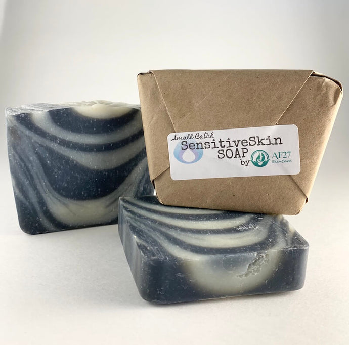 3 Bars of AF27 Sensitive Skin Soap which are handmade with care, 1 bar shown in our compostable package, the other 2 are opened 1 standing upright the other laying on it’s side.